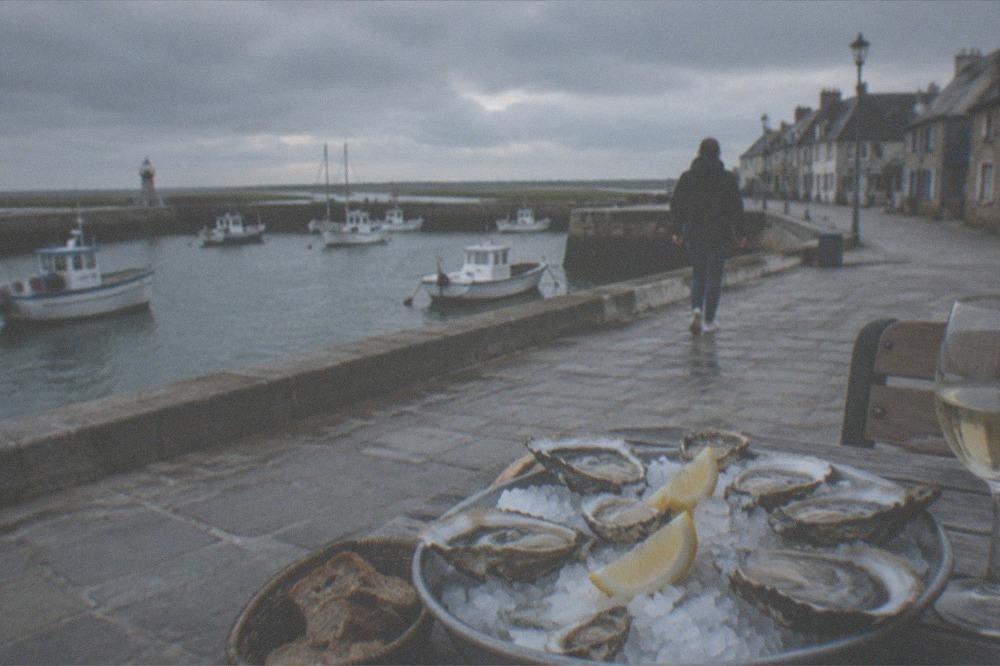 Fresh oysters on ice with lemon on a harbour-side restaurant table