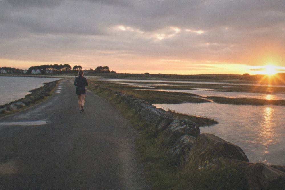 A calm evening over an Atlantic bay on the island with the sun setting behind low dunes