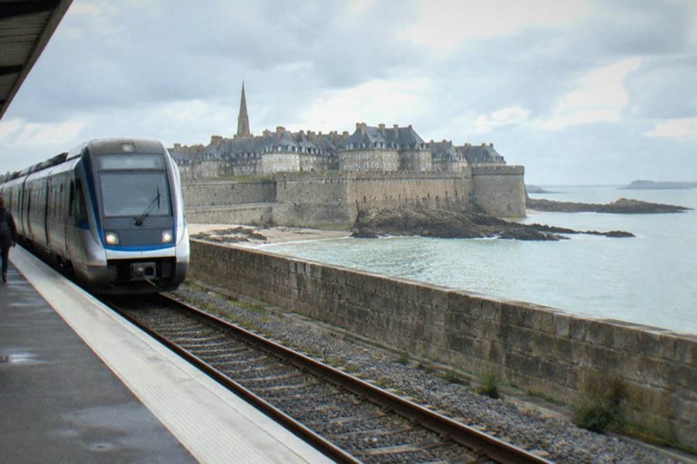 A modern regional train waiting at a French station platform in morning light