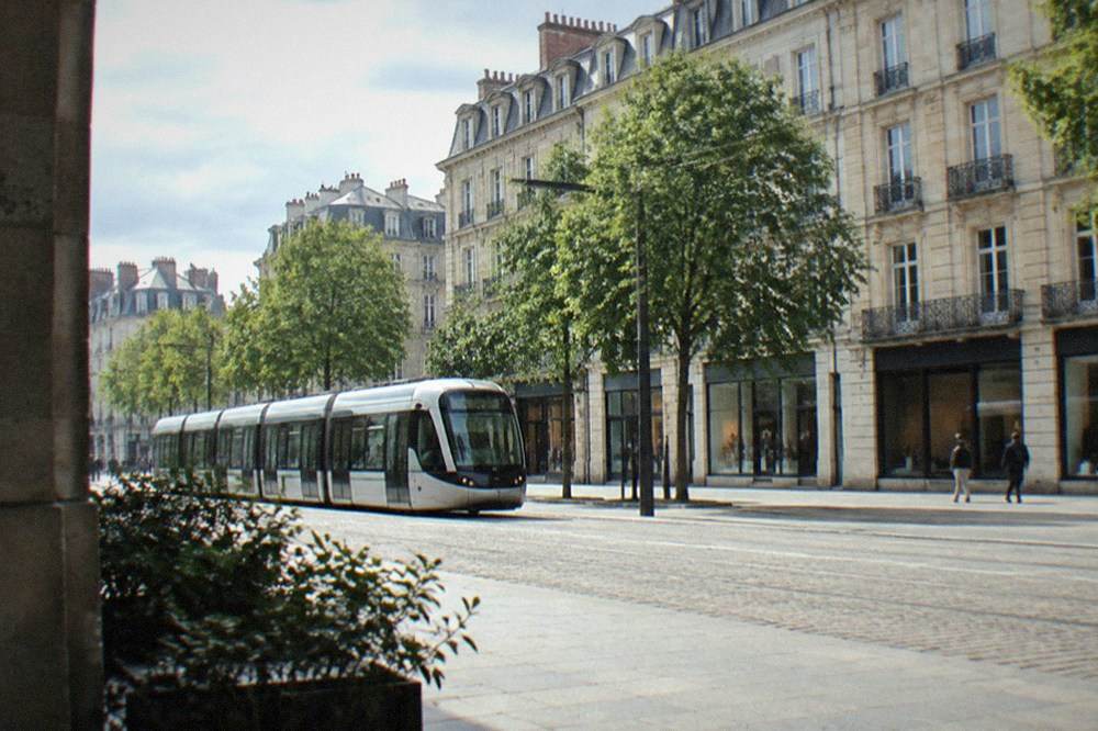 Modern tram in Nantes passing a row of stone buildings with shops at street level