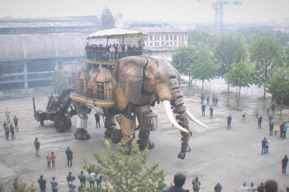 The mechanical elephant of Les Machines de l'ile standing on a wide flat plaza on the Ile de Nantes
