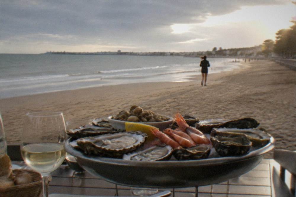 Oyster and seafood platter served on a seaside restaurant table overlooking the water