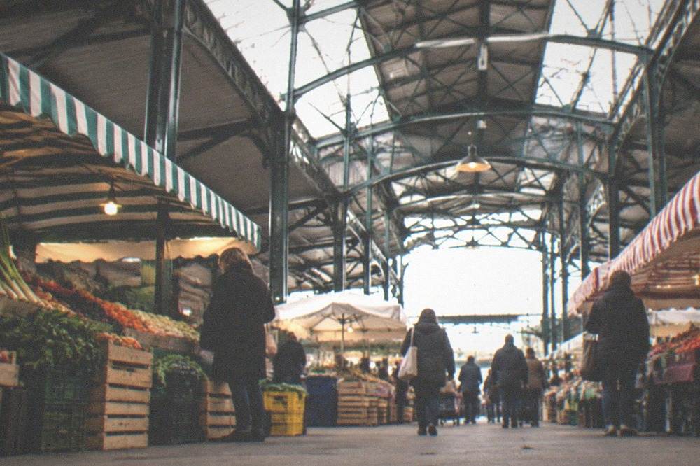 Stallholders and shoppers under the covered hall of Talensac market in Nantes in the morning
