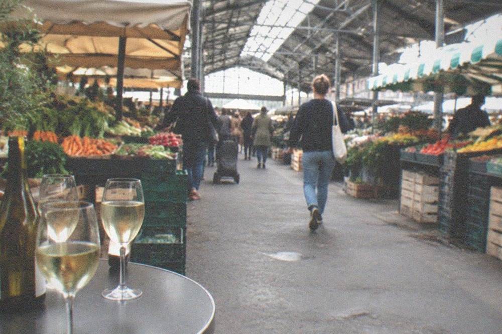 Two glasses of pale white wine on a café table beside a bottle