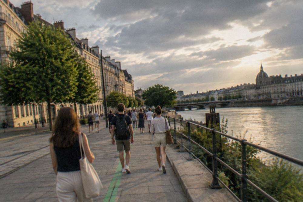 Visitors following a painted green line along a Nantes street in summer