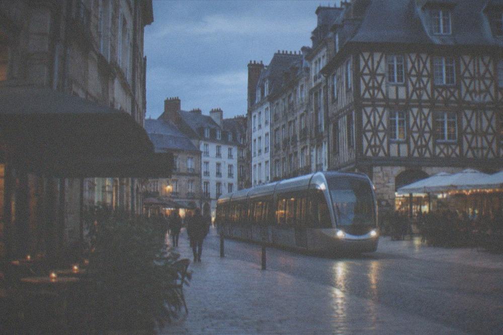 A modern tram passing along a pedestrianised street in a French city centre