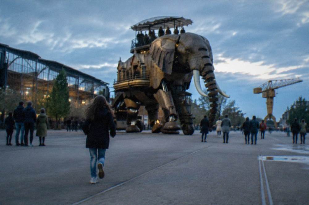 Visitors walking beside the Machines de l'île elephant on the Île de Nantes