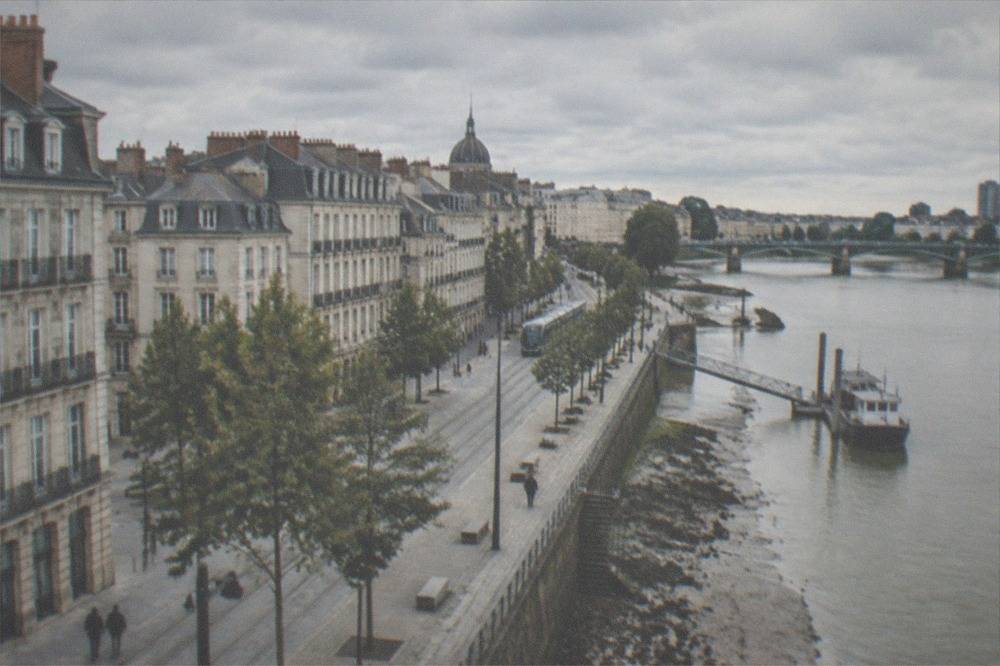 A small French river town with stone houses along a tidal river bank at low tide