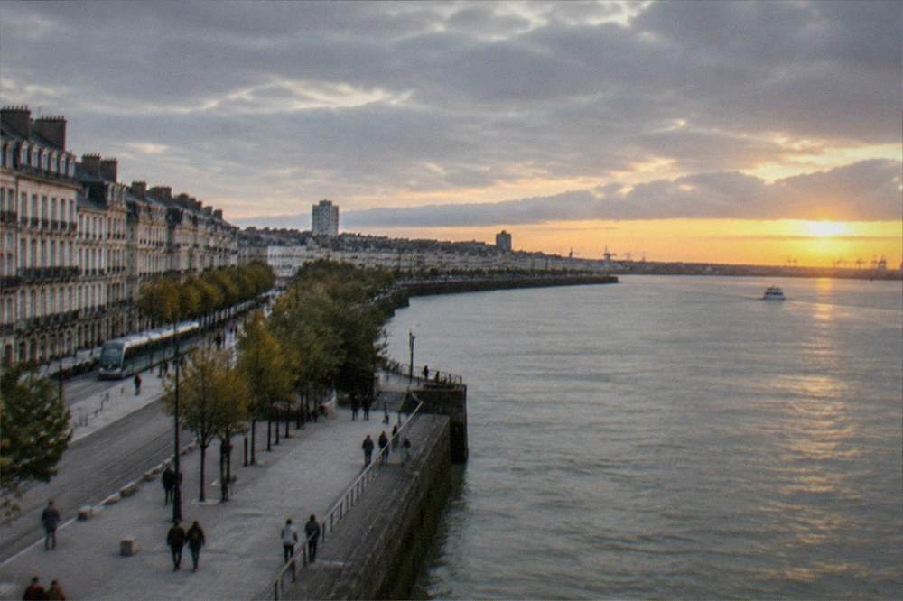 The wide Loire estuary at sunset with the outline of a distant port on the horizon