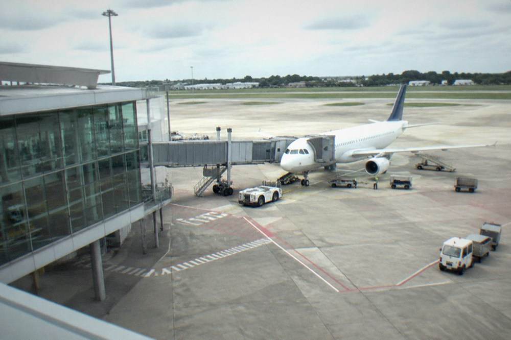 A departure board listing European and Canadian destinations above a modern airport concourse