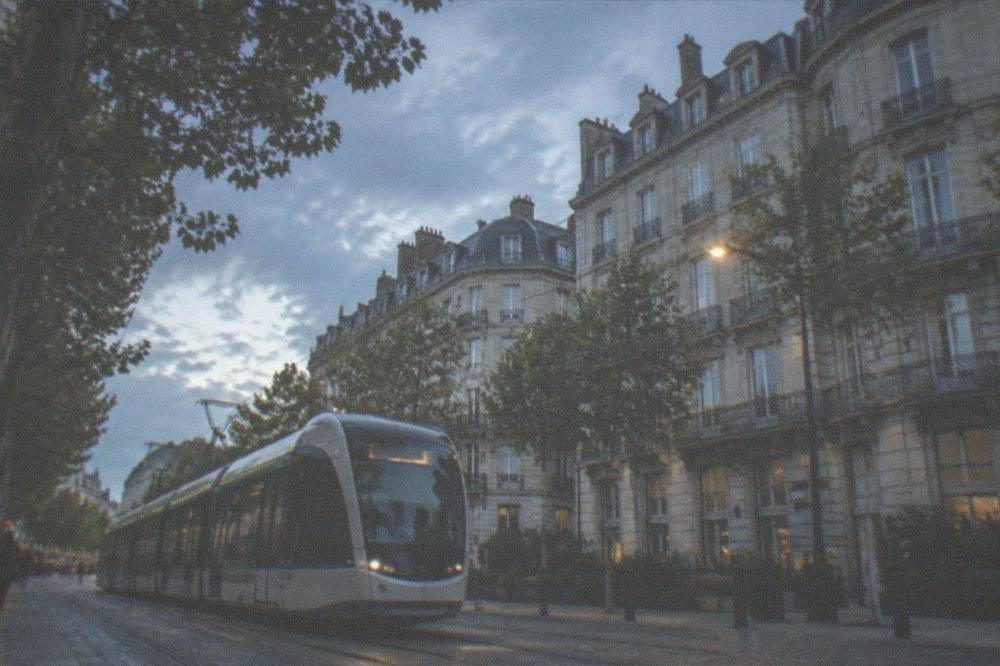 A Nantes tram gliding along a tree-lined street in the city centre