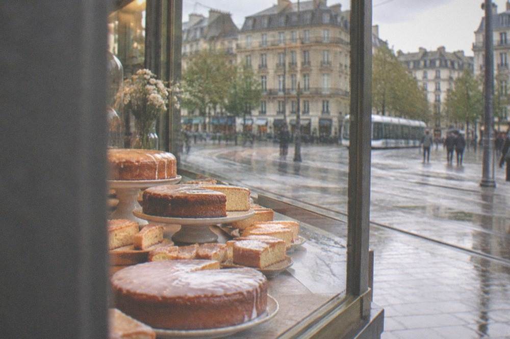 A display of whole and sliced gâteau nantais cakes in a patisserie window in central Nantes