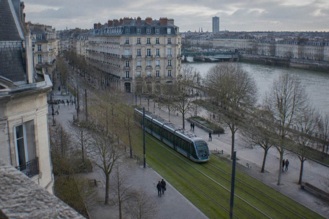A modern Nantes tram travelling along a grass-covered tram track in the city centre