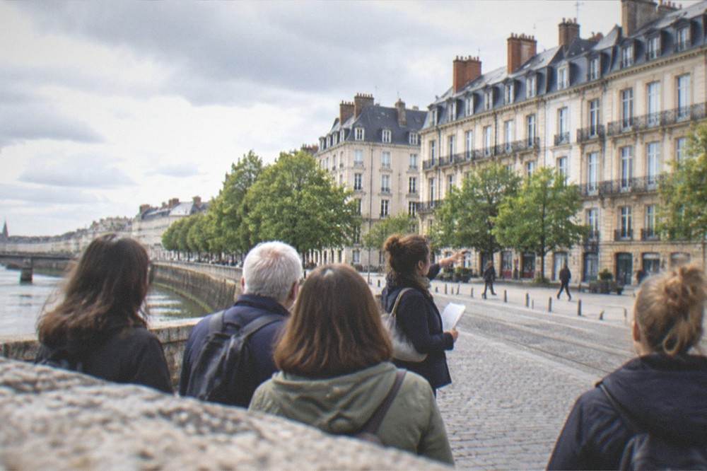 A guide pointing out historic facades to a small group on a walking tour in central Nantes