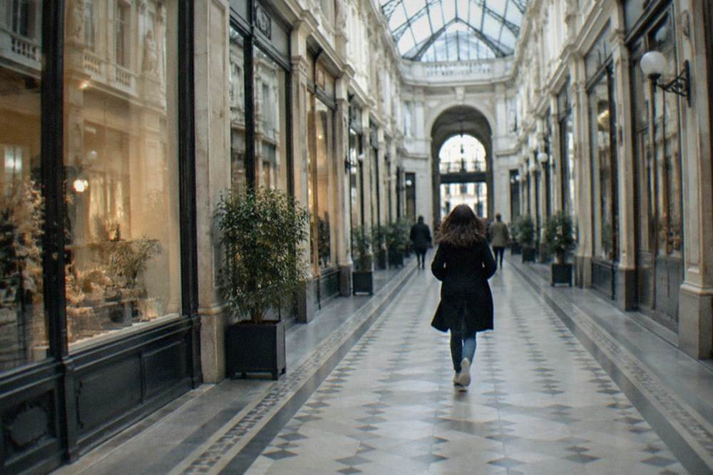The interior of a glass-roofed nineteenth-century shopping arcade in Nantes