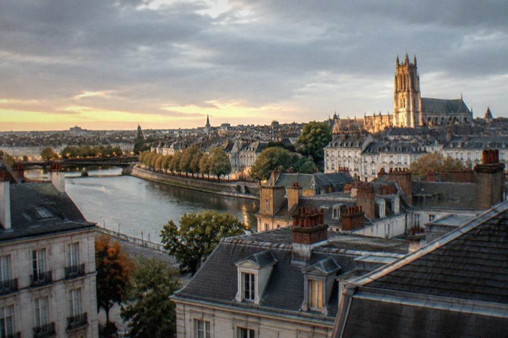 Evening view over the rooftops of Nantes with the cathedral tower lit in the background
