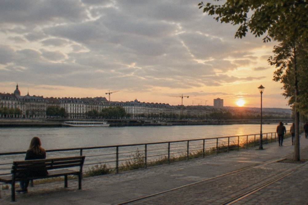 Cranes and rooftops of Nantes seen across the wide Loire river at dusk