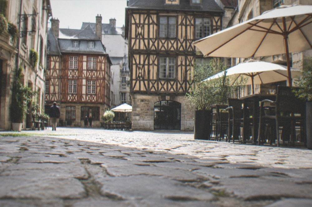Quiet morning street in the Bouffay old town of Nantes with half-timbered buildings and a café opening