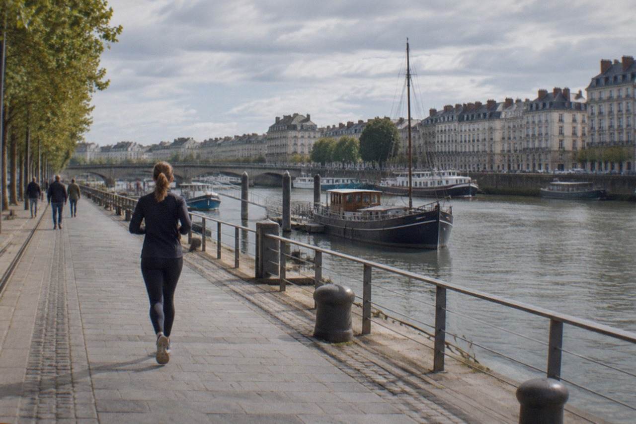 A riverside quay in Nantes with moored boats and old stone facades along the water