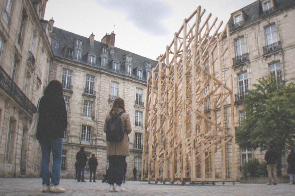 Visitors viewing contemporary art installed in a historic stone courtyard in Nantes