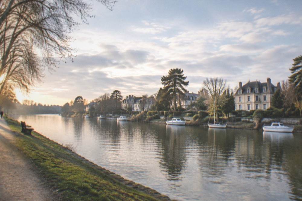The Erdre river in Nantes at golden hour with trees and a riverside path