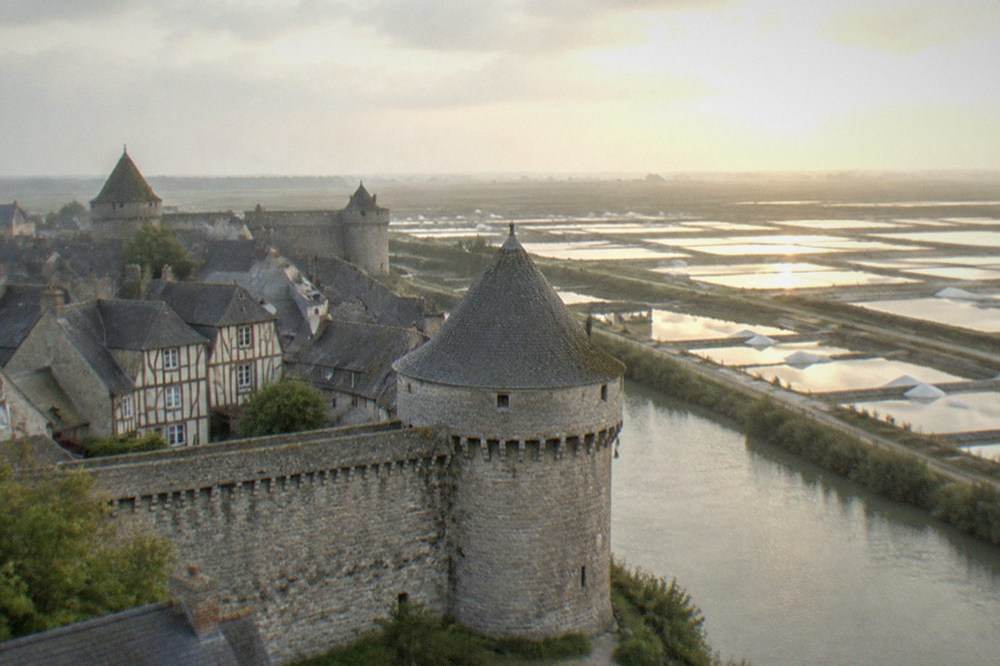 White salt mounds and marsh pools of the Guérande salt fields at golden hour