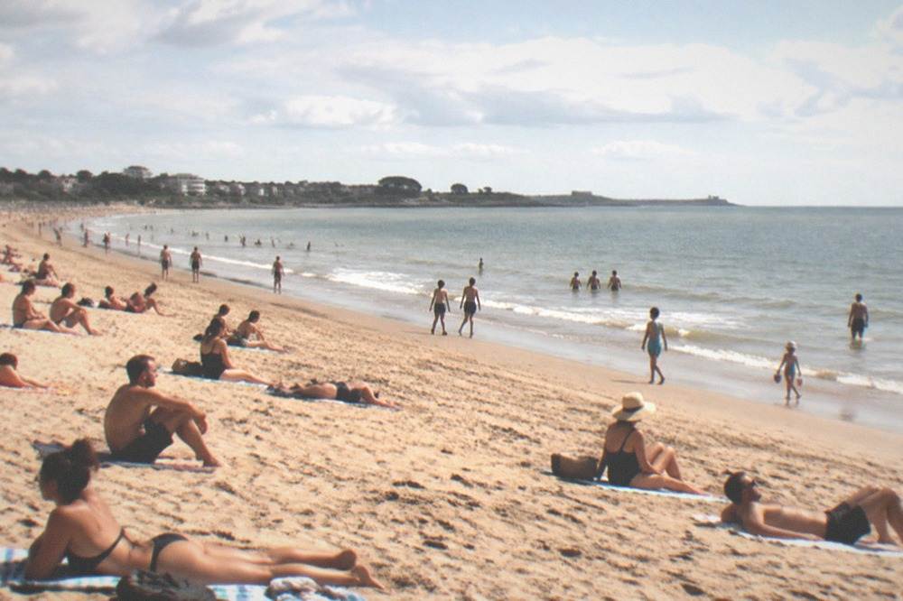 Sunbathers on a wide Atlantic beach in Loire-Atlantique on a clear summer day