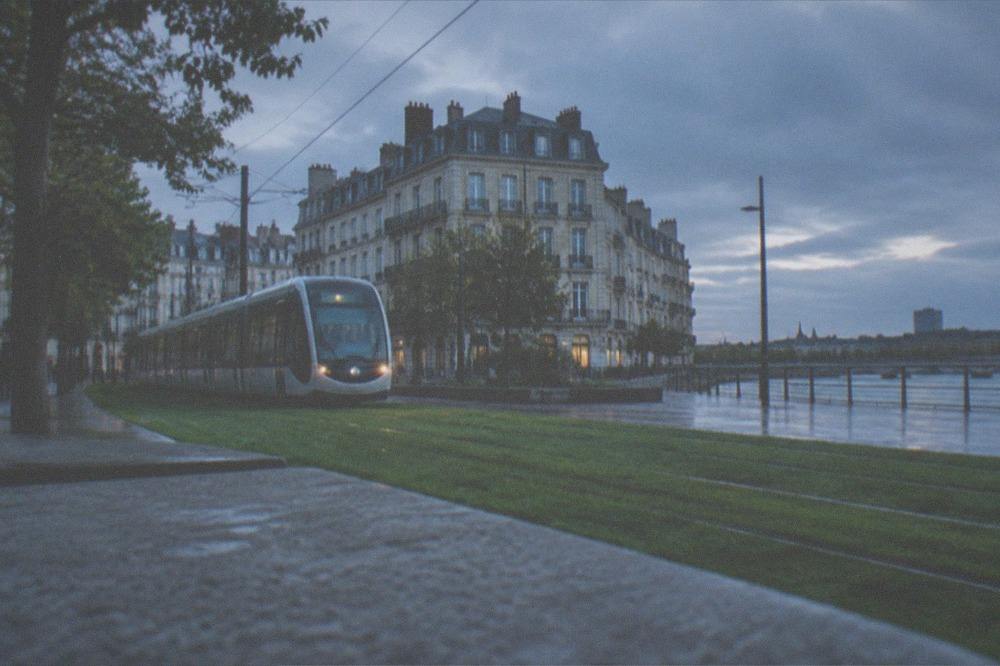 A Nantes tram gliding along a grass-covered track through the city centre