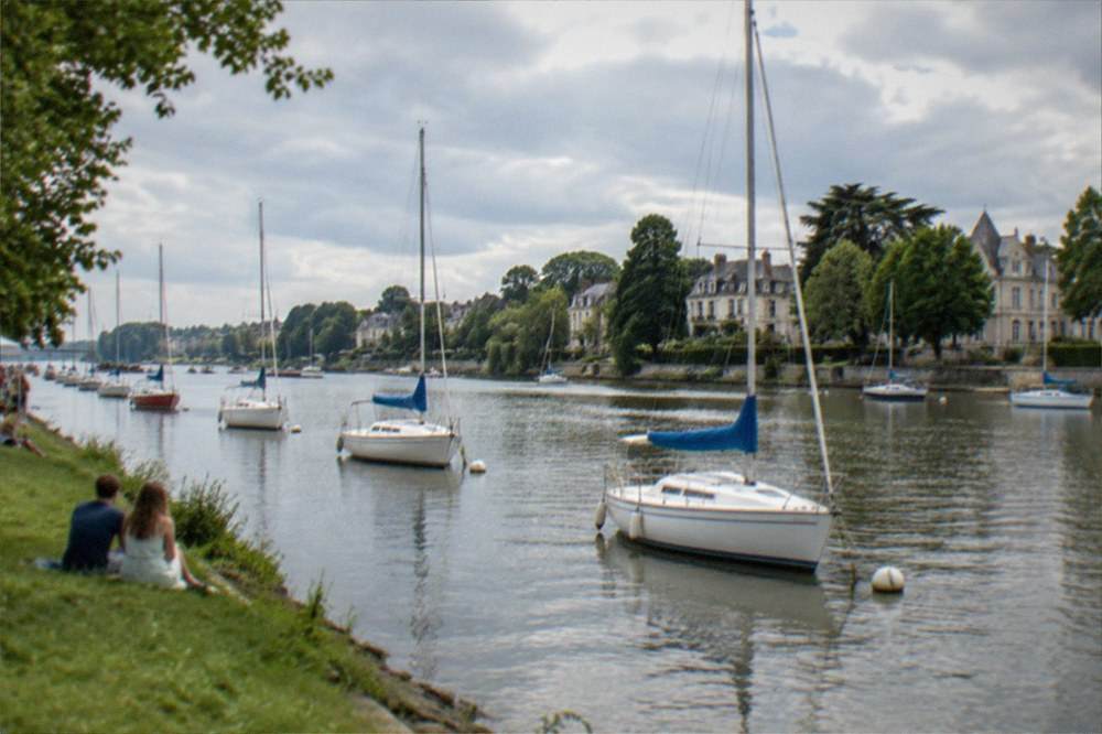 Sailboats moored along the Erdre river during a summer festival in Nantes