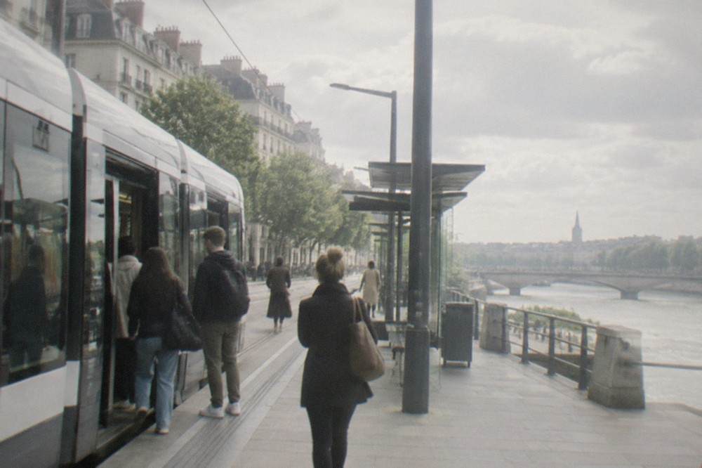 Passengers boarding a modern tram at a stop in central Nantes