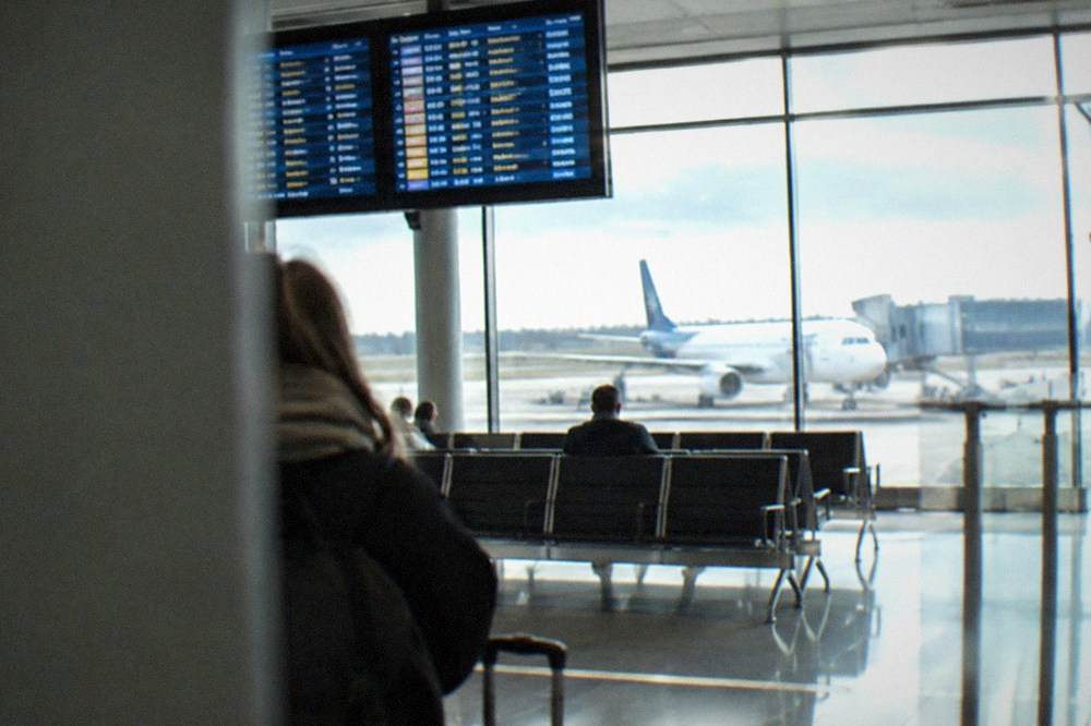 A departures board showing flight times inside Nantes Atlantique Airport terminal