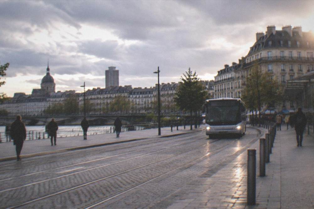 A shuttle bus approaching the station forecourt in Nantes with the city skyline beyond