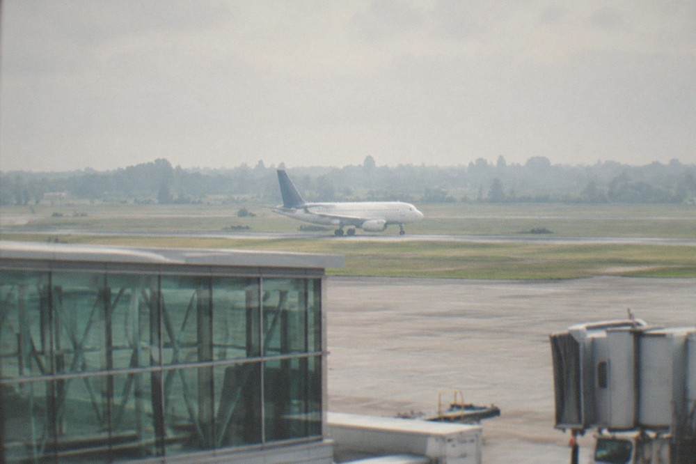A passenger aircraft on the runway at Nantes airport with green fields beyond
