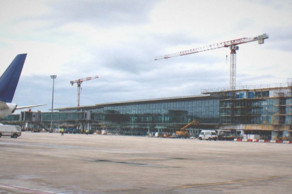 Construction cranes and scaffolding around a airport terminal facade