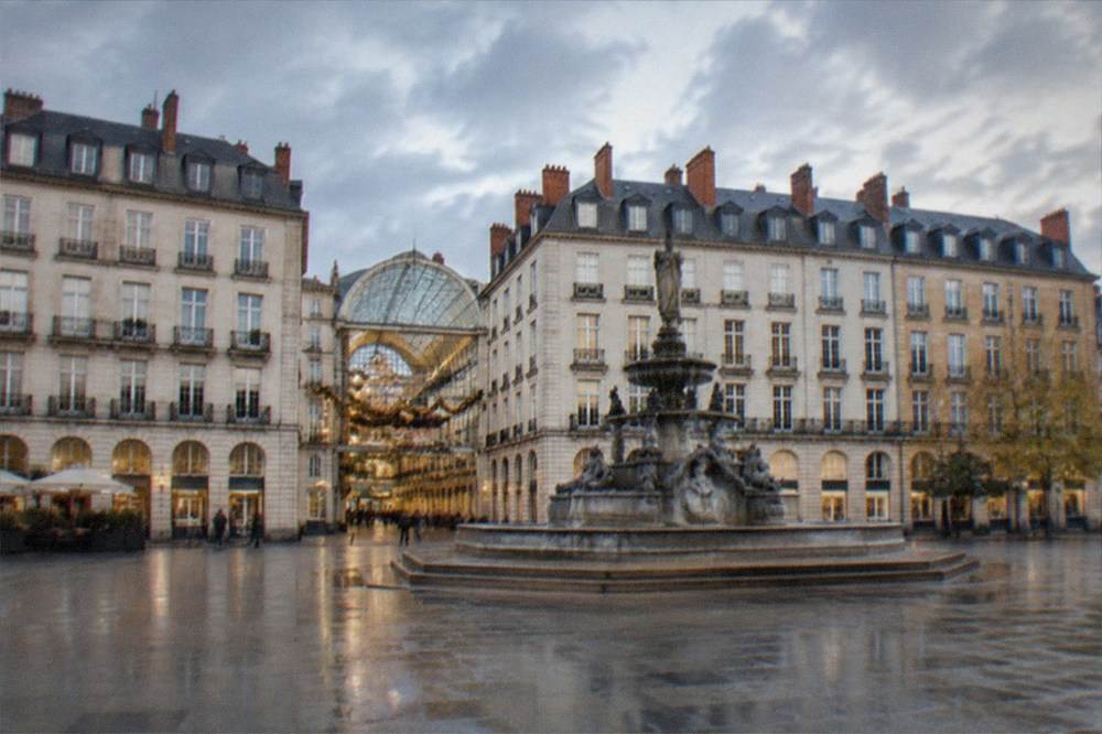 A glass-roofed 19th-century shopping gallery lit up with festive garlands