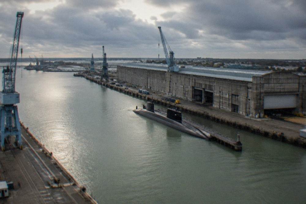 A grey naval submarine base building beside a harbour in a French Atlantic coastal town