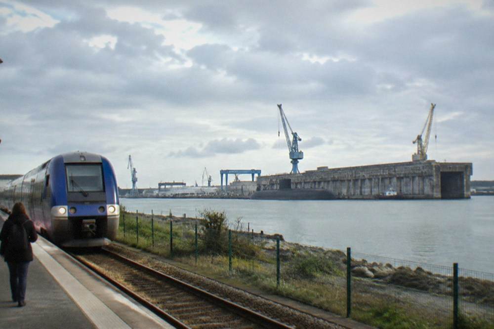 A French regional train arriving at a small town station platform near the coast