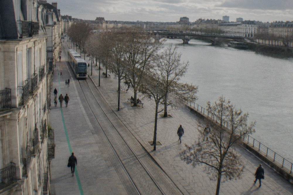 A painted green line running along a pavement in Nantes, guiding visitors past old stone buildings