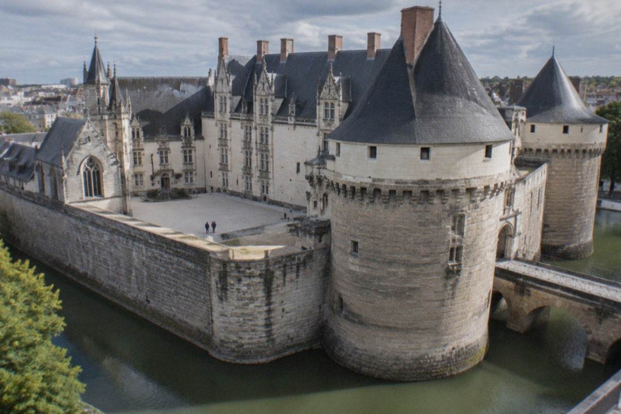 The ramparts and Renaissance facade of the Chateau des ducs de Bretagne in Nantes under a daytime sky