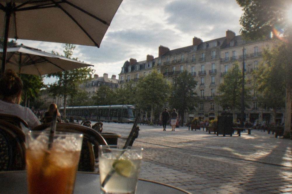 A shaded cafe terrace with parasols and iced drinks on a warm afternoon in central Nantes