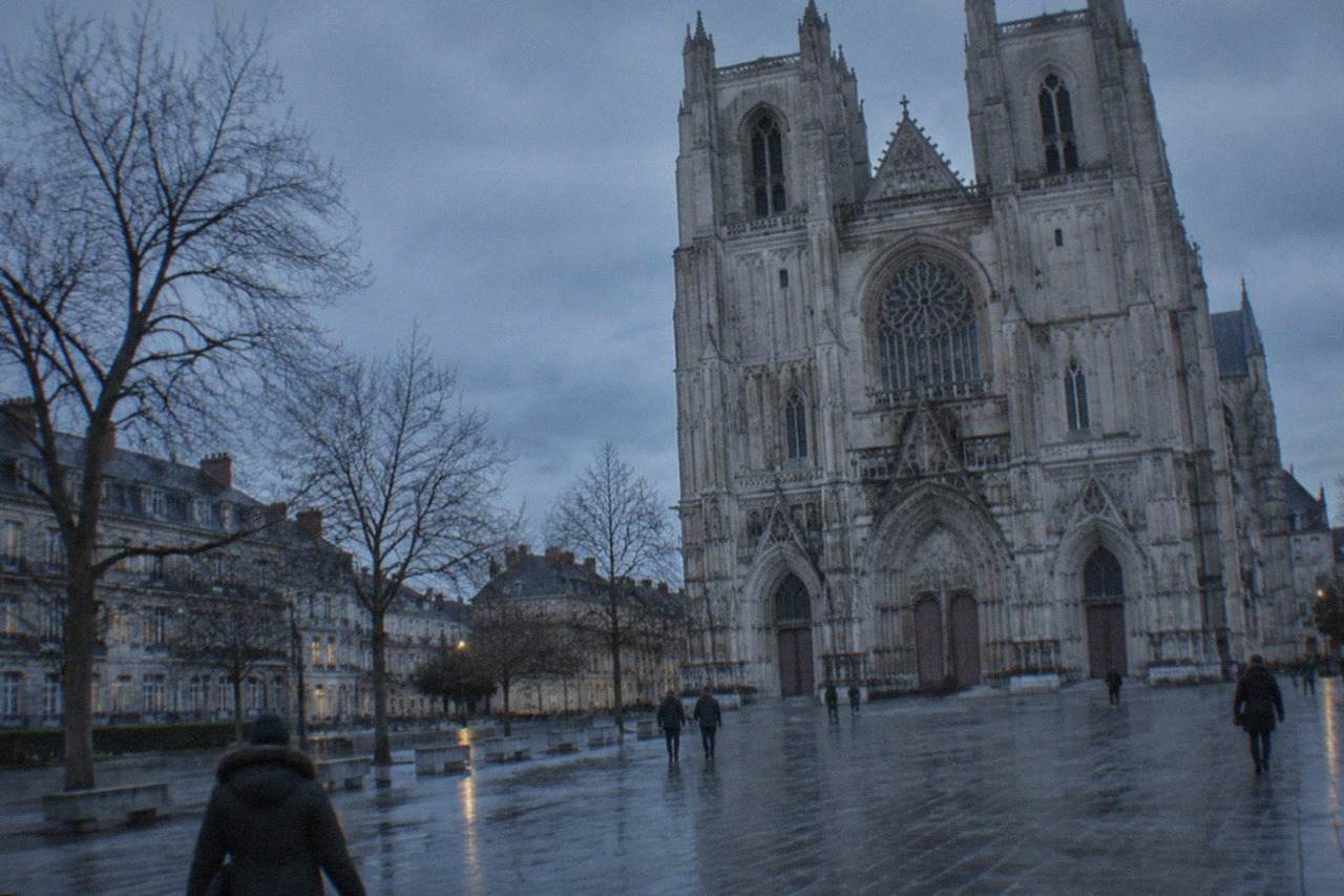 Nantes cathedral seen across a quiet square on an overcast winter afternoon with bare trees