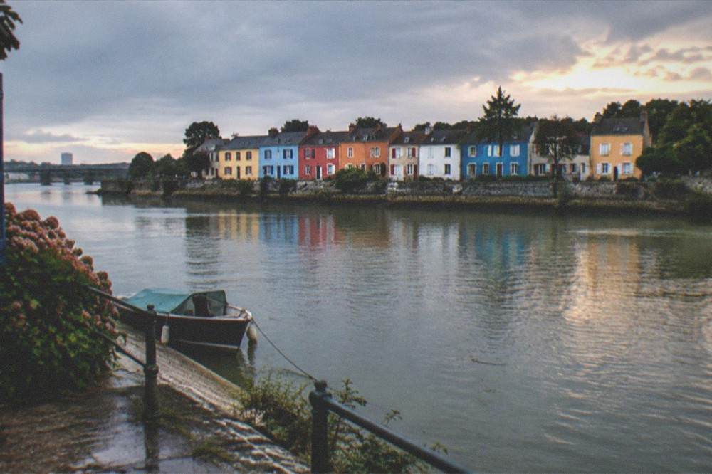Coloured fishermen's houses in Trentemoult seen across the Loire at dusk
