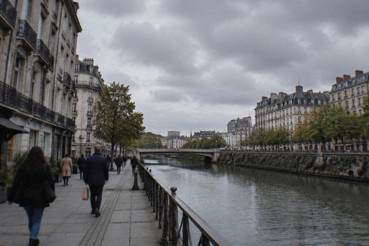 Shoppers walking along a canal-side street in central Nantes lined with old stone buildings