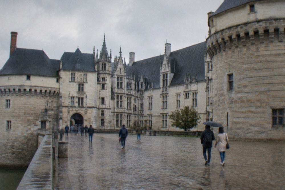 Visitors crossing the stone courtyard of the Château des ducs de Bretagne on a bright morning