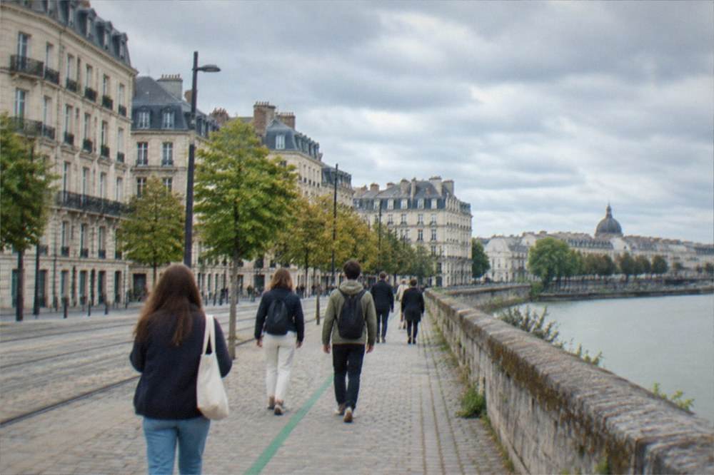 A small group following a painted green line along a Nantes street past historic facades
