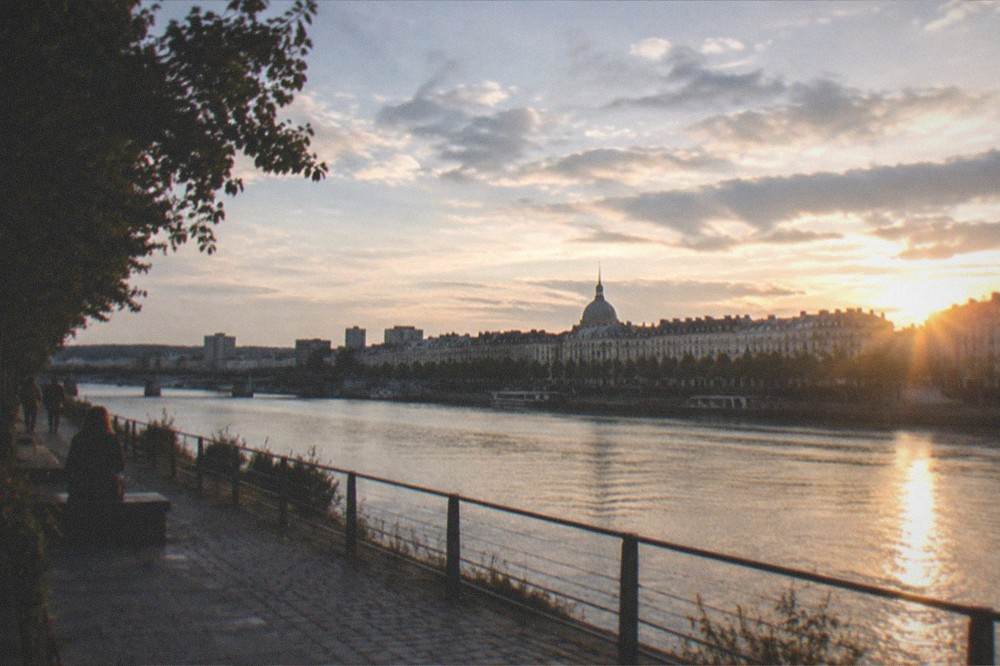 Sunset light over the Loire river with the Nantes skyline and a bridge in the distance