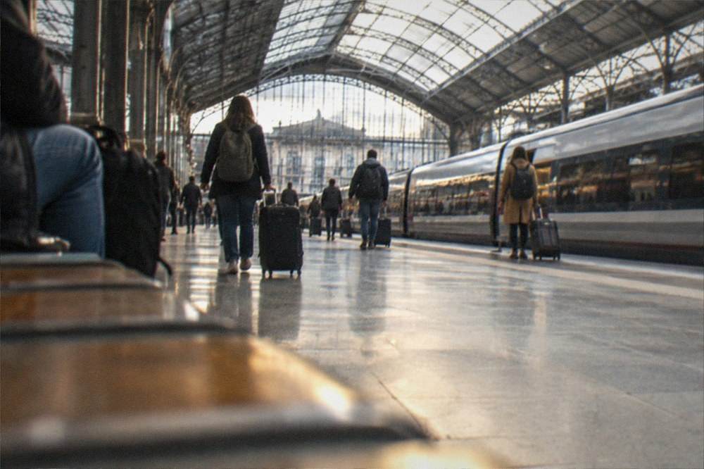 The interior of Nantes train station with travellers at the platforms beneath the glass roof
