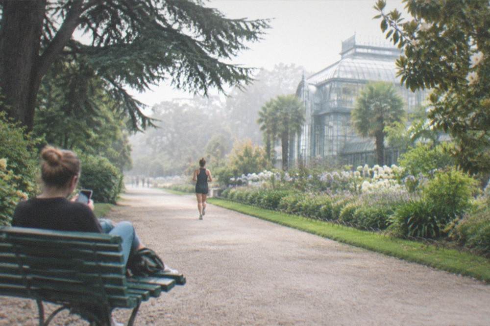 A traveller practising with a phone on a bench in the Jardin des Plantes in Nantes