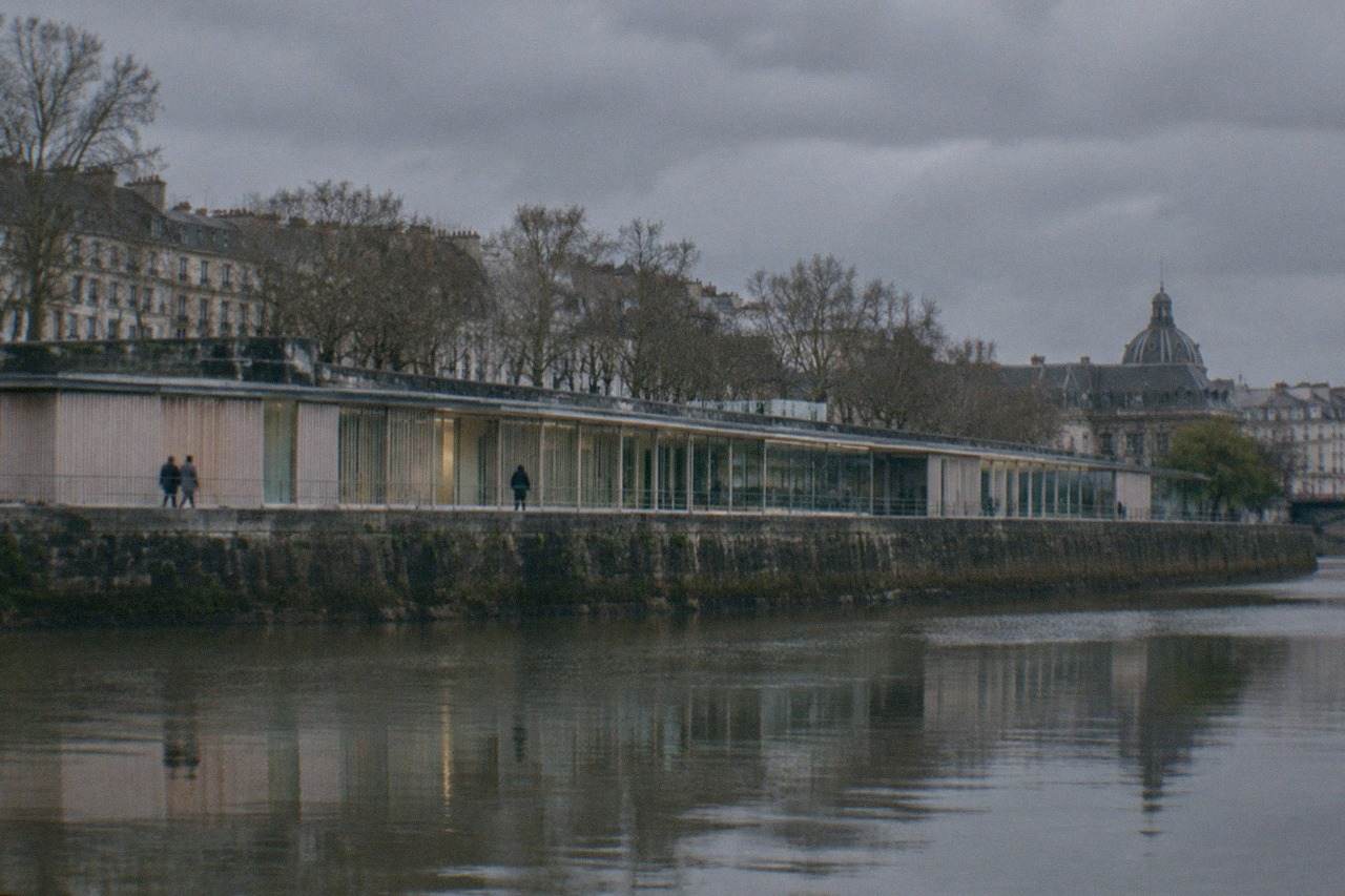 A riverside memorial walkway along the Loire with engraved stone walls reflecting on the water
