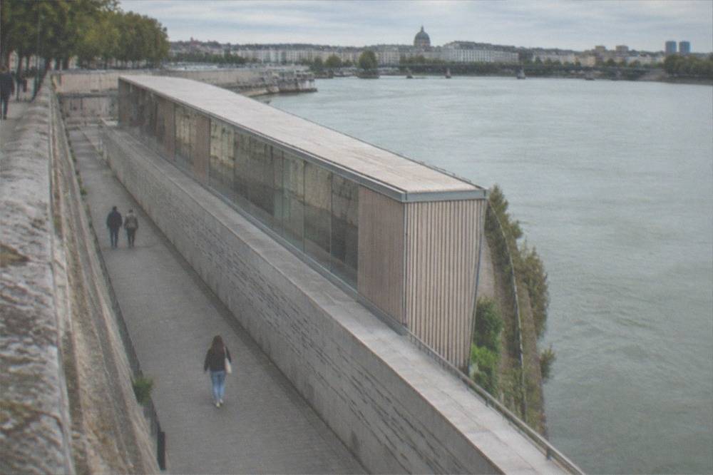 An underground walkway beside the Loire with names engraved along a long stone wall